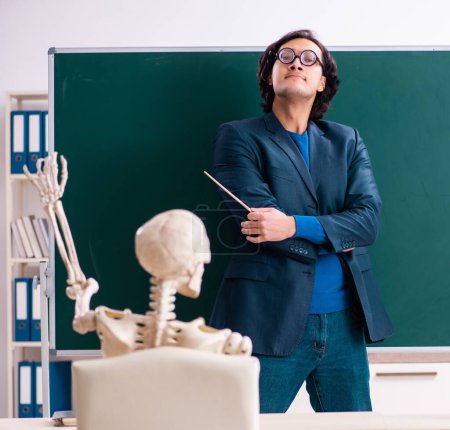 Foto de El profesor masculino y estudiante de esqueleto en el aula - Imagen libre de derechos