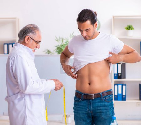 Foto de El médico dietista dando consejos al paciente con sobrepeso de grasa - Imagen libre de derechos