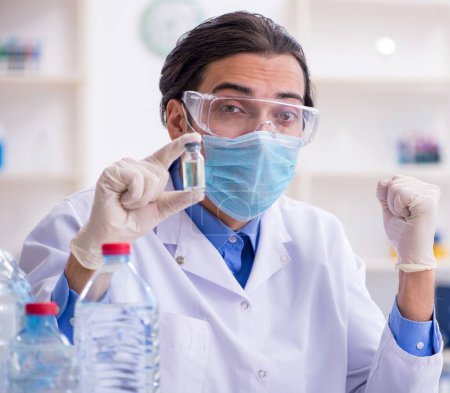 Téléchargez les photos : Le jeune chimiste masculin expérimentant en laboratoire - en image libre de droit