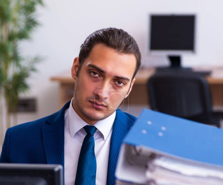 Téléchargez les photos : Employé masculin mécontent du travail excessif au bureau - en image libre de droit