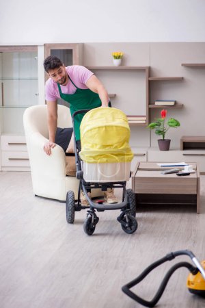 Photo for Young contractor cleaner looking after newborn - Royalty Free Image