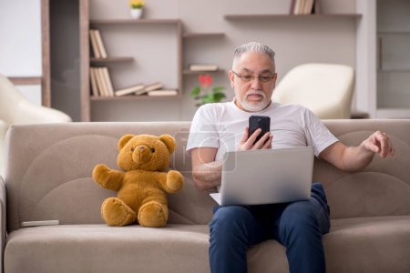 Photo for Old man with toy bear at the home - Royalty Free Image