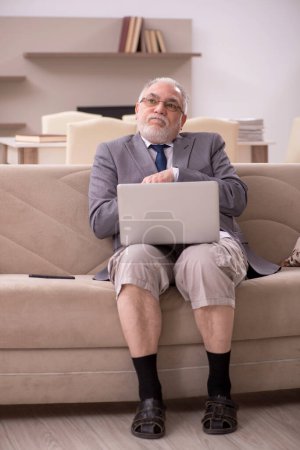 Téléchargez les photos : Un vieil homme d'affaires qui travaille à domicile pendant une pandémie - en image libre de droit