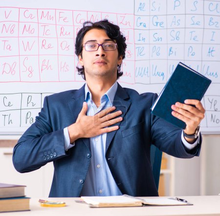 Téléchargez les photos : The young male chemistry teacher in front of periodic table - en image libre de droit
