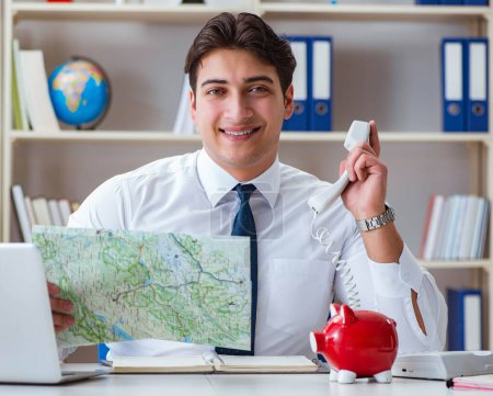 Téléchargez les photos : L'homme d'affaires agent de voyage travaillant dans le bureau - en image libre de droit
