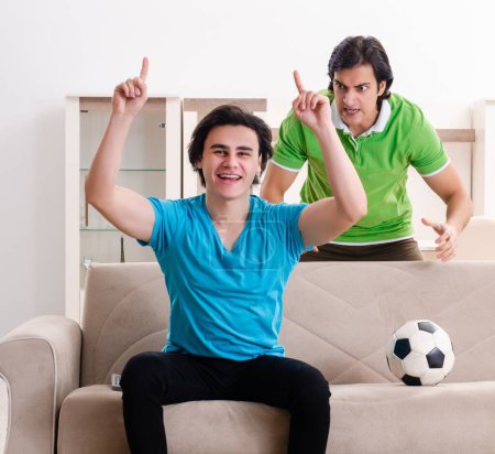 Téléchargez les photos : Les amis regardant le football à la maison - en image libre de droit