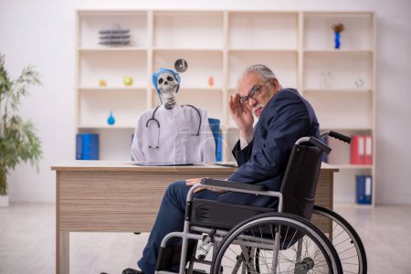 Foto de Viejo paciente masculino en silla de ruedas visitando al doctor diablo - Imagen libre de derechos