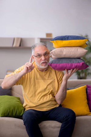 Foto de Hombre viejo con muchas almohadas en casa - Imagen libre de derechos