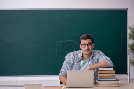 Téléchargez les photos : Jeune étudiant assis dans la salle de classe - en image libre de droit