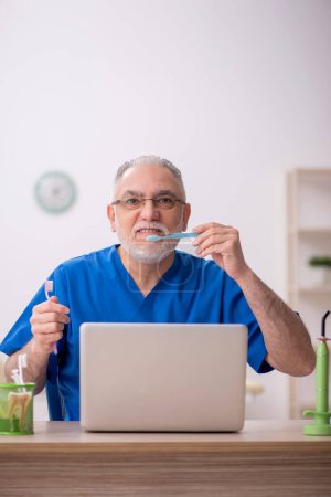 Téléchargez les photos : Vieux dentiste travaillant à l'hôpital - en image libre de droit
