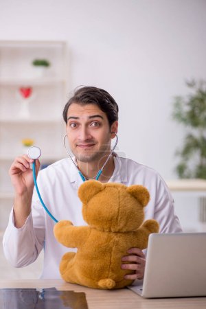 Foto de Joven doctor sosteniendo juguete oso - Imagen libre de derechos