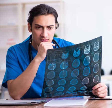 Foto de El joven doctor mirando imágenes de rayos X - Imagen libre de derechos