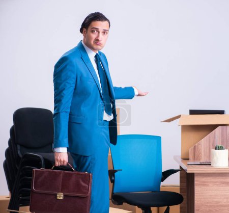 Foto de El joven hombre de negocios guapo siendo despedido de su trabajo - Imagen libre de derechos