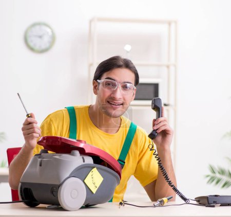Photo for The man repairman repairing vacuum cleaner - Royalty Free Image