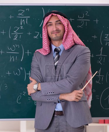 Téléchargez les photos : Le professeur arabe portant un costume devant le tableau - en image libre de droit