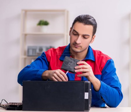 Téléchargez les photos : Jeune réparateur masculin réparer ordinateur PC - en image libre de droit
