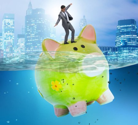 Foto de El hombre de negocios en concepto de deuda con Piggybank - Imagen libre de derechos
