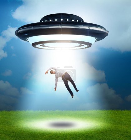 Photo for The flying saucer abducting young businessman - Royalty Free Image