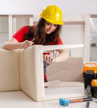 Photo for The female contractor repairing furniture at home - Royalty Free Image