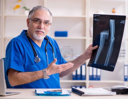 Foto de The white bearded old doctor radiologist working in clinic - Imagen libre de derechos