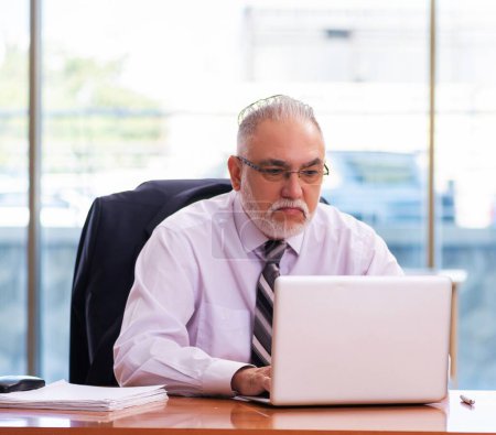 Téléchargez les photos : Employé d'affaires principal travaillant dans le bureau - en image libre de droit