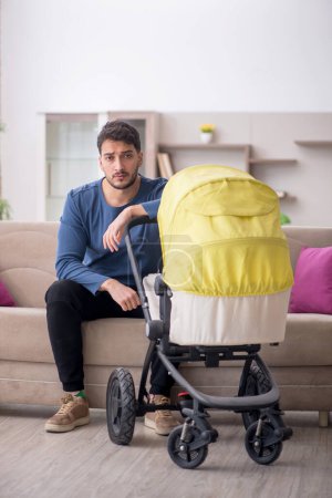 Téléchargez les photos : Homme s'occupant d'un nouveau-né à la maison - en image libre de droit