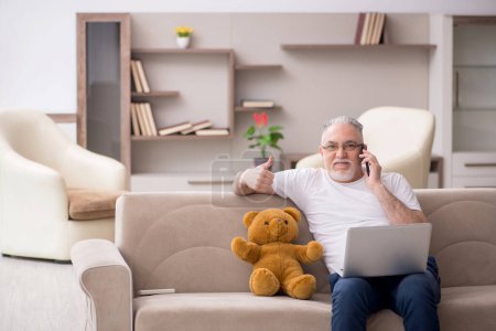Téléchargez les photos : Vieil homme avec ours jouet à la maison - en image libre de droit