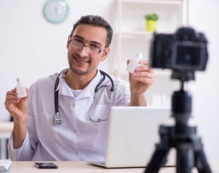 Photo for The young male doctor recording video for his blog - Royalty Free Image