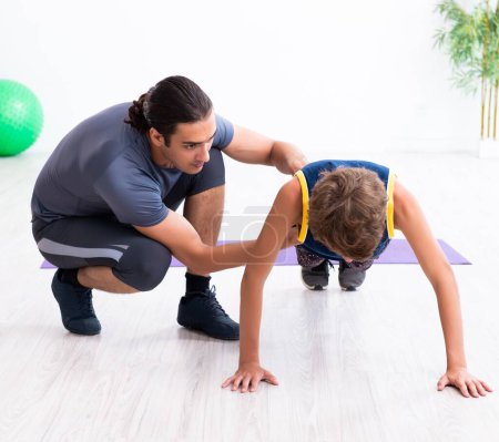 Foto de El joven padre y su hijo haciendo ejercicios - Imagen libre de derechos