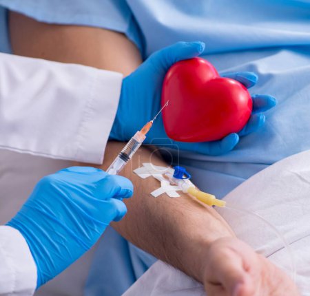 Téléchargez les photos : Le patient de sexe masculin recevant une transfusion sanguine à l'hôpital - en image libre de droit