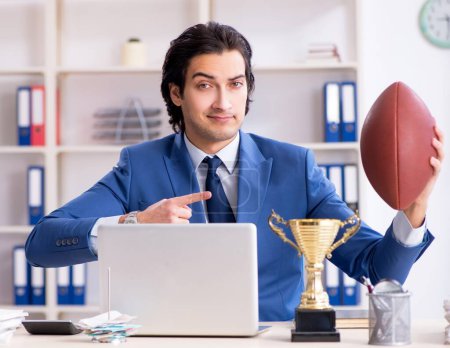 Photo for The young handsome businessman with rugby ball in the office - Royalty Free Image
