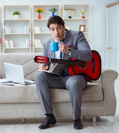 Photo for The businessman playing guitar at home - Royalty Free Image