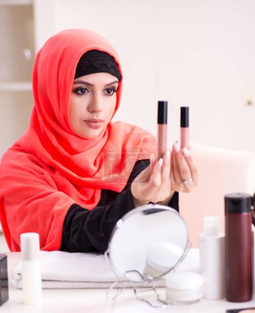 Foto de La hermosa mujer en hiyab aplicando maquillaje - Imagen libre de derechos