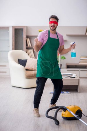 Photo for Young blinfolded contractor cleaning the house - Royalty Free Image