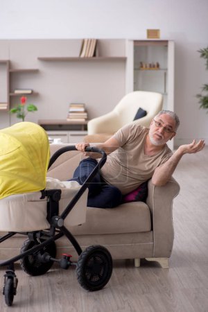 Foto de Hombre anciano que cuida del recién nacido en casa - Imagen libre de derechos