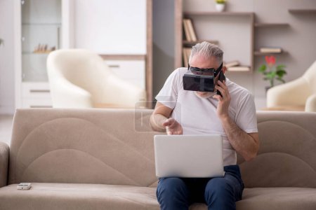 Téléchargez les photos : Homme âgé jouissant de lunettes virtuelles à la maison - en image libre de droit