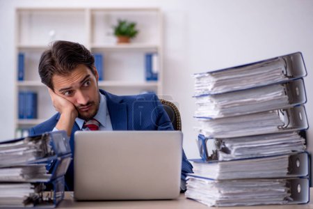 Téléchargez les photos : Jeune homme d'affaires employé et trop de travail au bureau - en image libre de droit