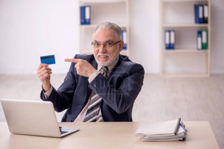 Photo for Old boss employee holding credit card - Royalty Free Image