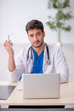 Photo for Young doctor suggesting pills in the clinic - Royalty Free Image