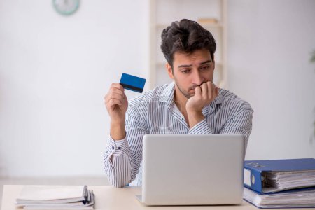 Téléchargez les photos : Jeune employé titulaire d'une carte de crédit - en image libre de droit