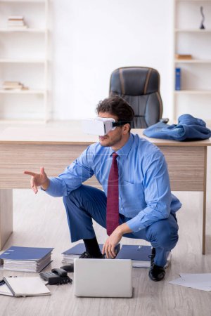 Téléchargez les photos : Jeune employé profitant de lunettes virtuelles sur le lieu de travail - en image libre de droit
