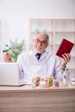 Téléchargez les photos : Vieux médecin tenant modèle moléculaire - en image libre de droit