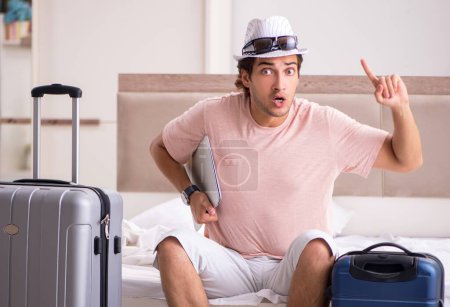 Foto de El hombre con la maleta en el dormitorio esperando el viaje - Imagen libre de derechos