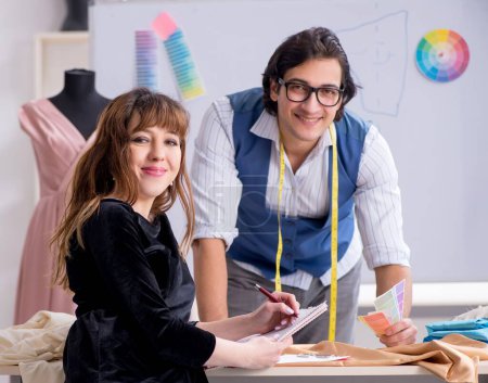 Photo for The young male tailor teaching female student - Royalty Free Image