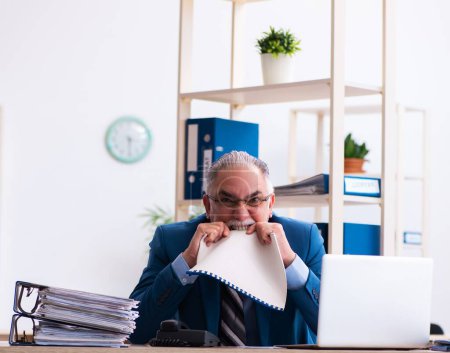 Téléchargez les photos : Gardien comptable senior mécontent du travail excessif sur le lieu de travail - en image libre de droit