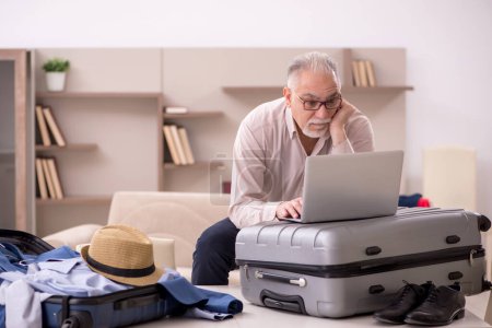 Téléchargez les photos : Aged man preparing for trip at home - en image libre de droit