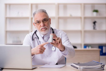 Téléchargez les photos : Vieux médecin masculin suggérant des pilules à l'hôpital - en image libre de droit