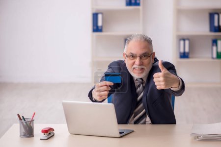 Photo for Old boss employee holding credit card - Royalty Free Image