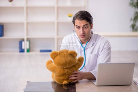 Téléchargez les photos : Jeune médecin tenant un ours jouet - en image libre de droit