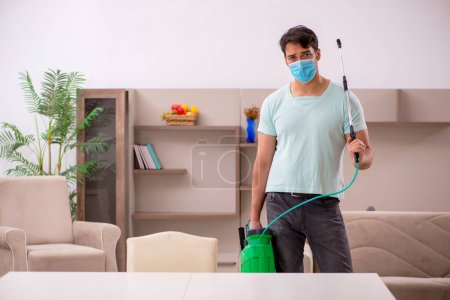 Photo for Young contractor doing pest control at home - Royalty Free Image